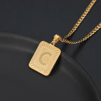 Colar com inicial gravada e corrente cubana da Wulgor, destaque para o pingente com detalhe em relevo e acabamento elegante.