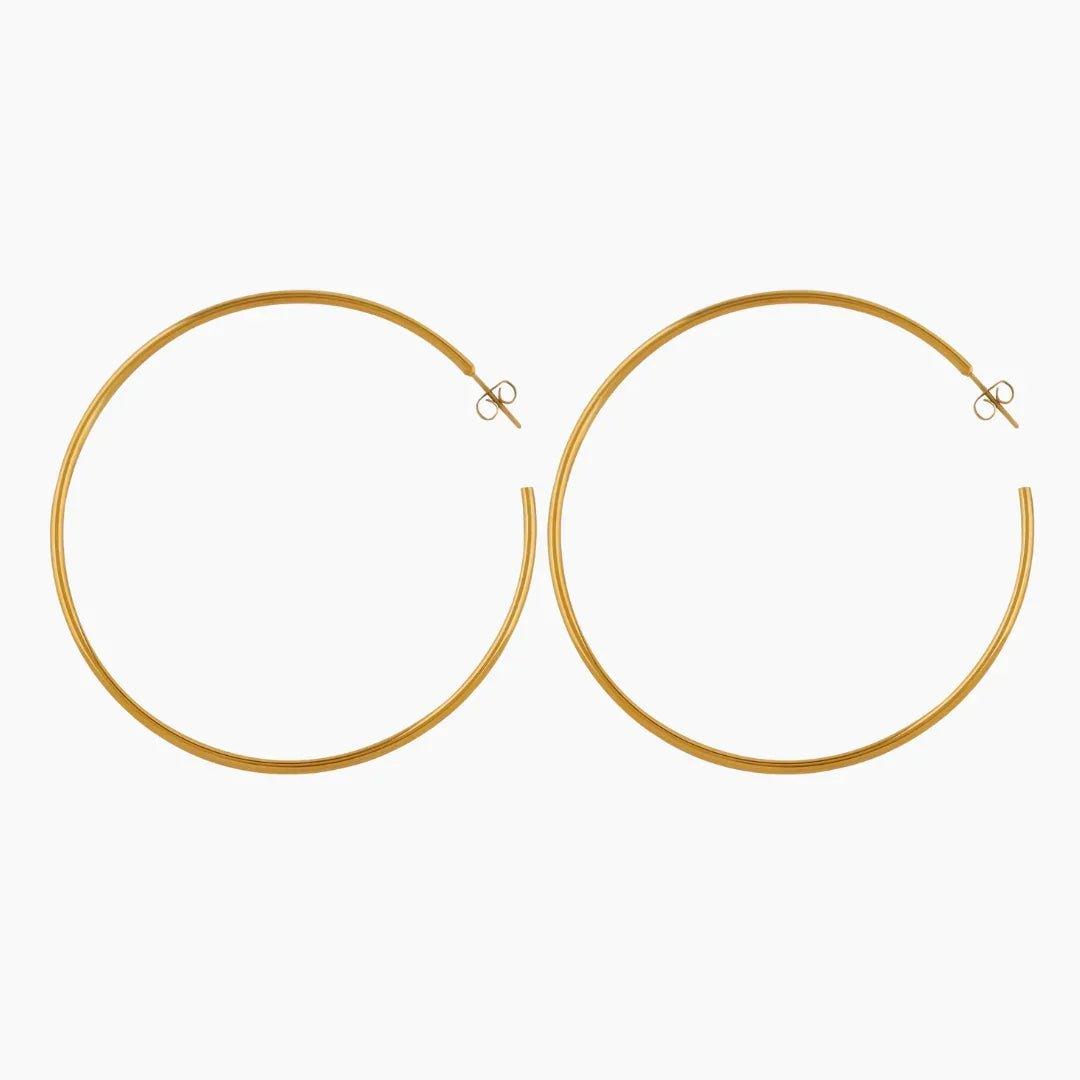 Brincos de argola da marca Wulgor, estilo clássico, feitos de metal dourado, exibidos em close-up com fundo neutro.