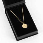 Colar zodiacal com moeda e corrente de corda, joia elegante da marca Wulgor, em destaque na imagem.